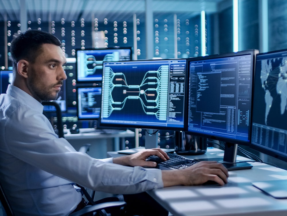 Professional looks at multiple monitors containing data