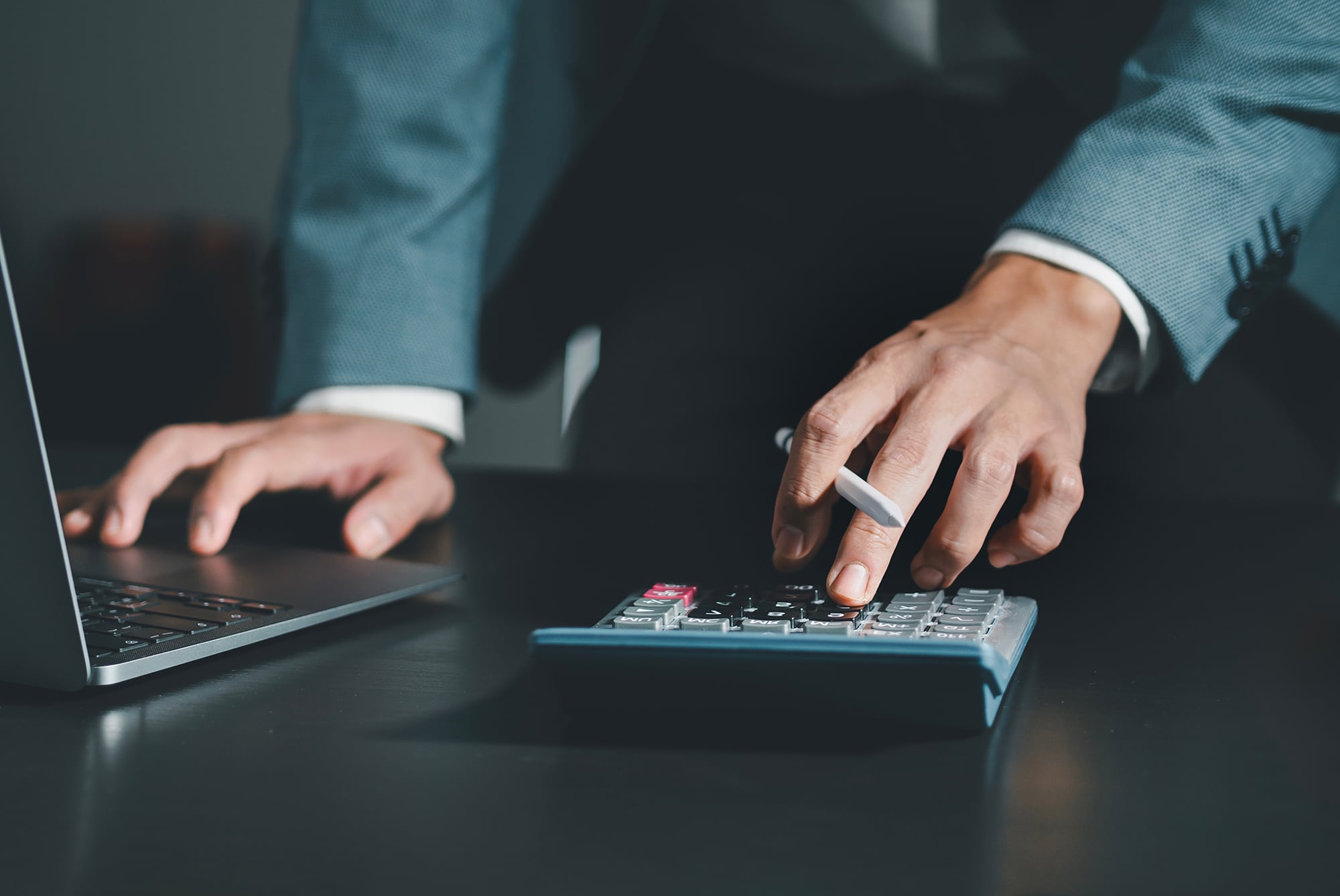 Close up of business using calculator to calculate financial reports