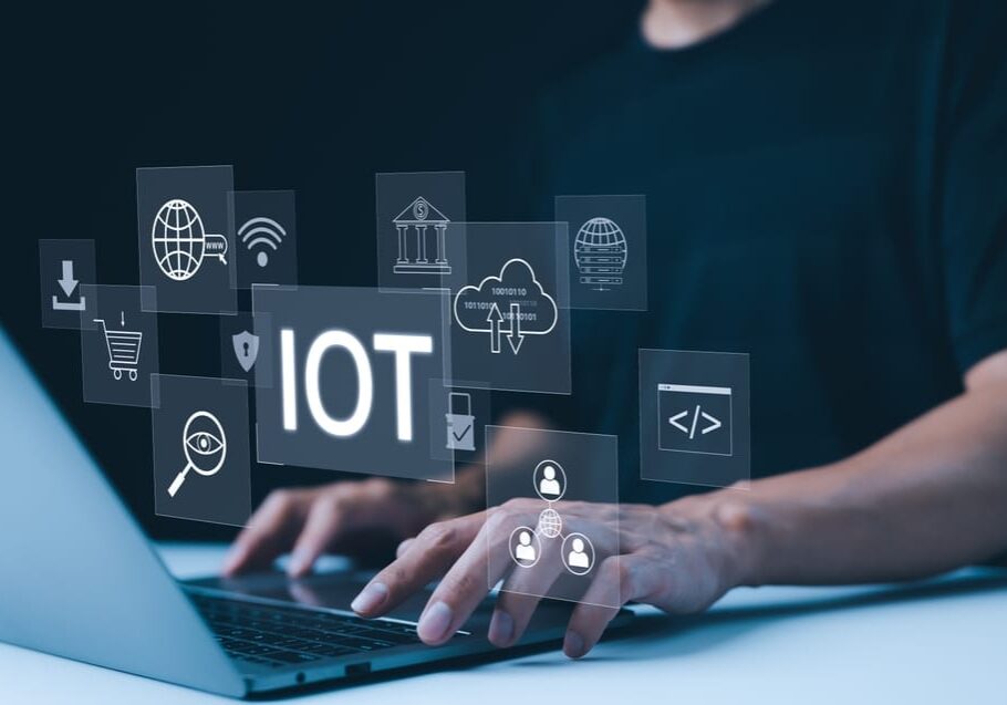 A person working on laptop with digital icons representing the Internet of Things