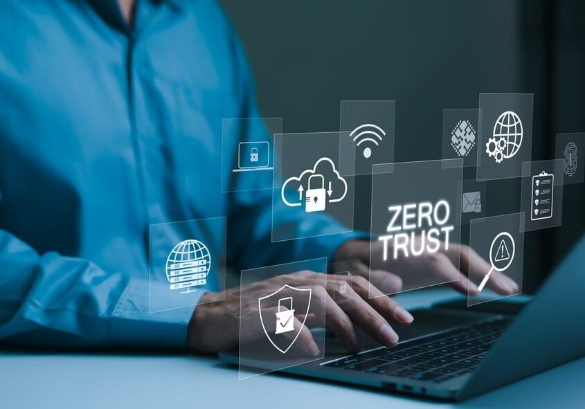 person types on a laptop with virtual icons zero trust security person types on a laptop with virtual icons zero trust security