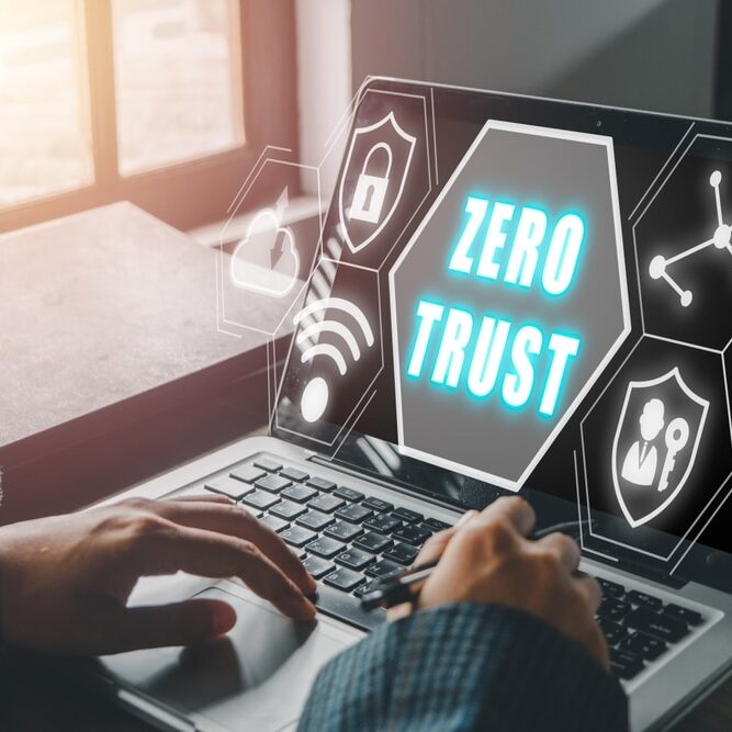 Person using computer with zero trust icon on virtual screen